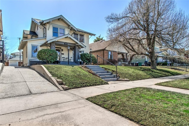 view of front of home with a front yard, fence, driveway, stairs, and a garage