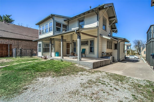 rear view of house featuring a patio area, a yard, and fence