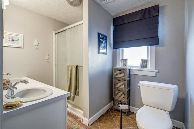 bathroom featuring a sink, a textured ceiling, a shower stall, and toilet