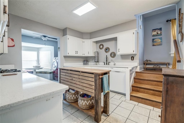 kitchen featuring light tile patterned floors, a ceiling fan, white cabinets, and white dishwasher