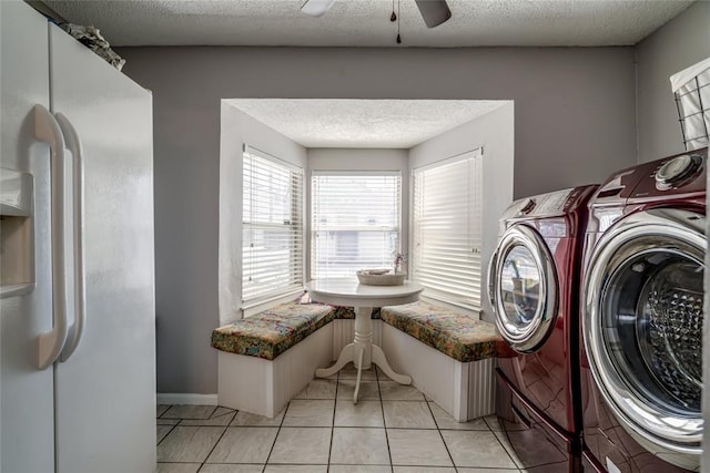 laundry area with light tile patterned floors, laundry area, washer and dryer, a textured ceiling, and a ceiling fan