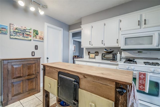 kitchen with white cabinetry, white appliances, light tile patterned flooring, and wood counters