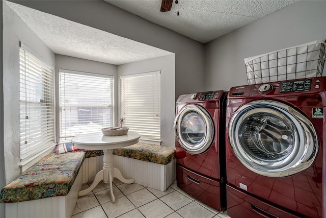 washroom featuring tile patterned flooring, washer and dryer, a textured ceiling, and a healthy amount of sunlight