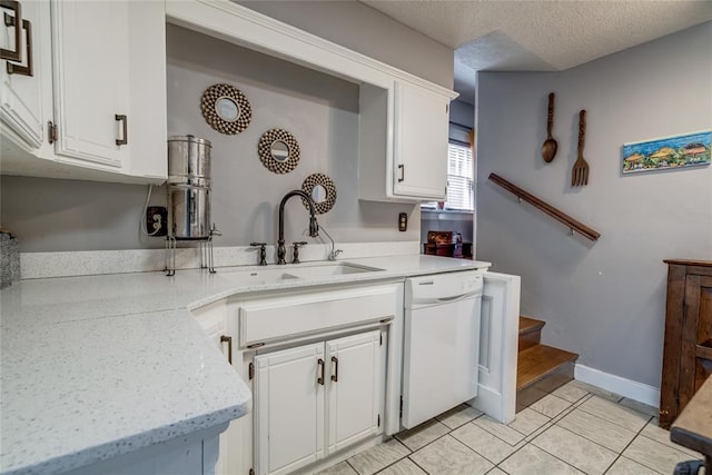 kitchen featuring light tile patterned flooring, white dishwasher, a sink, white cabinets, and a textured ceiling