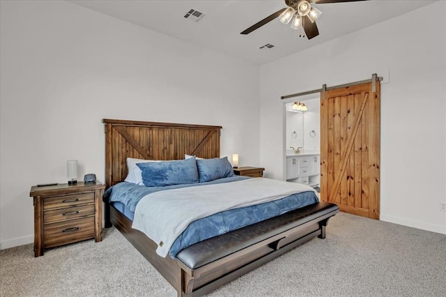 bedroom with a barn door, carpet, visible vents, and baseboards