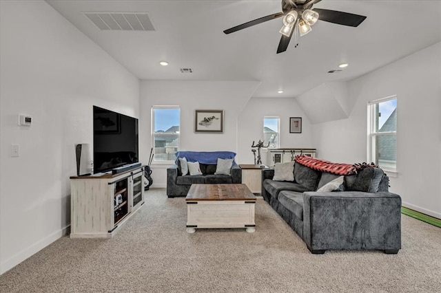 carpeted living room with visible vents, plenty of natural light, baseboards, and ceiling fan