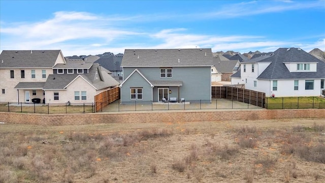 rear view of property with a residential view and a fenced backyard