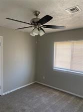 spare room with visible vents, baseboards, and a ceiling fan