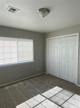 unfurnished bedroom with baseboards, visible vents, and a closet