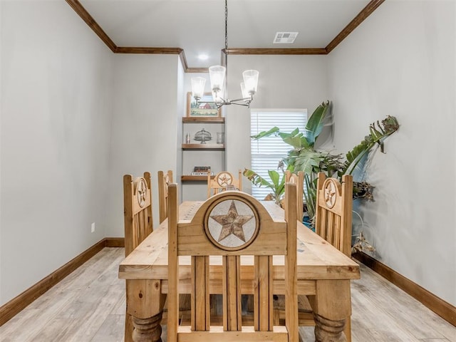 dining area with a chandelier, visible vents, light wood-type flooring, and ornamental molding