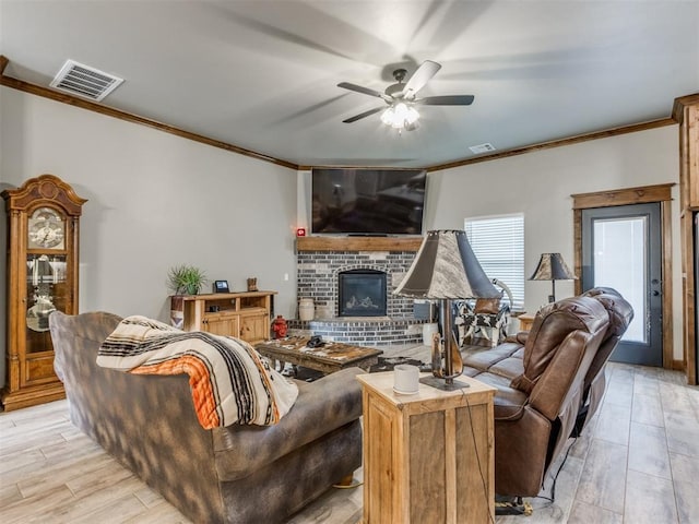 living area featuring visible vents, ceiling fan, crown molding, and light wood-style floors