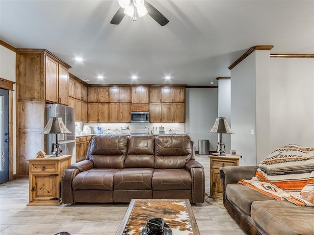 living room featuring recessed lighting, light wood-style flooring, a ceiling fan, and ornamental molding