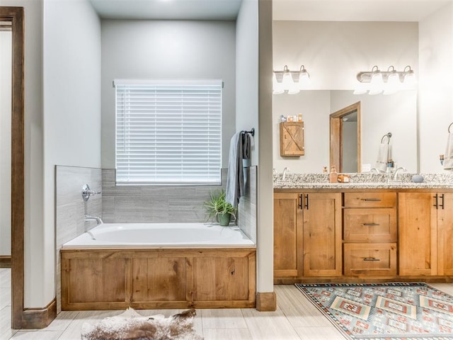 bathroom featuring a sink, a garden tub, and double vanity