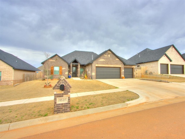 view of front of property featuring fence, brick siding, a garage, and driveway