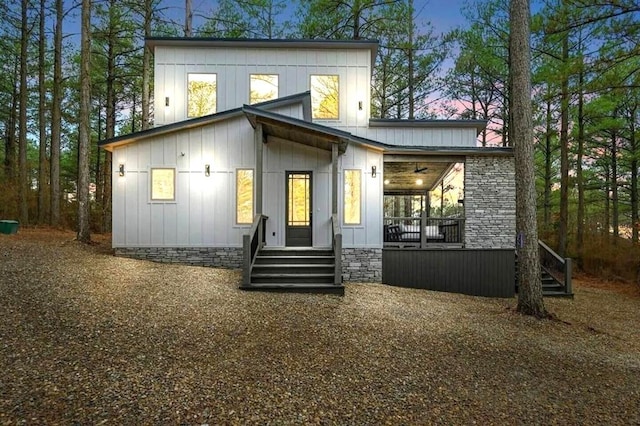 rear view of property featuring covered porch and board and batten siding