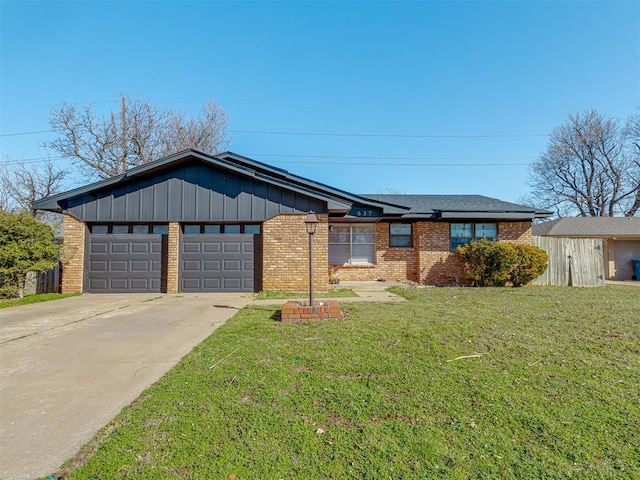 view of front of property with brick siding, a garage, a front lawn, and driveway