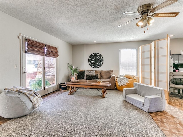 living room with a textured ceiling and a ceiling fan