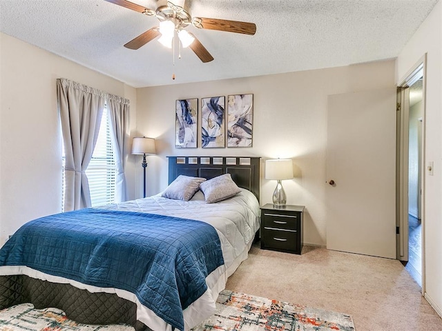 bedroom featuring ceiling fan, carpet, and a textured ceiling