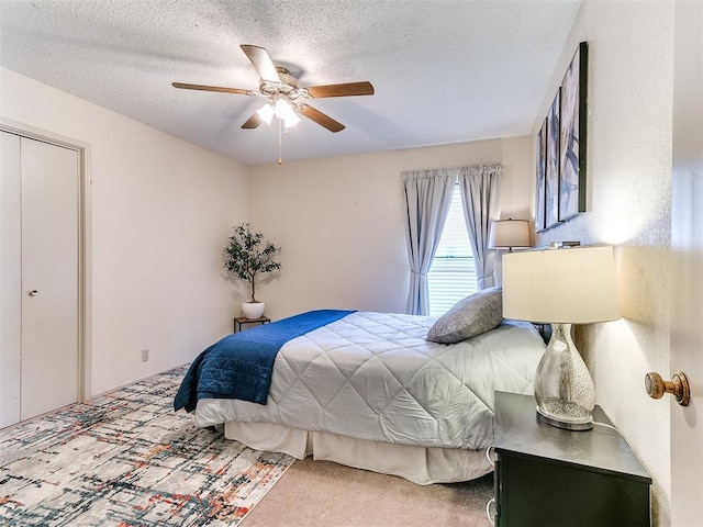 bedroom with a textured ceiling, a ceiling fan, and carpet floors