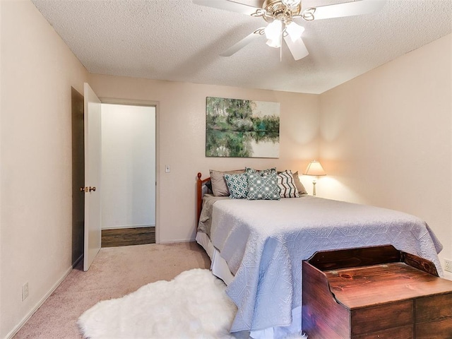 bedroom with baseboards, ceiling fan, a textured ceiling, and carpet