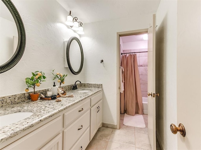 bathroom featuring tile patterned flooring, double vanity, baseboards, and a sink