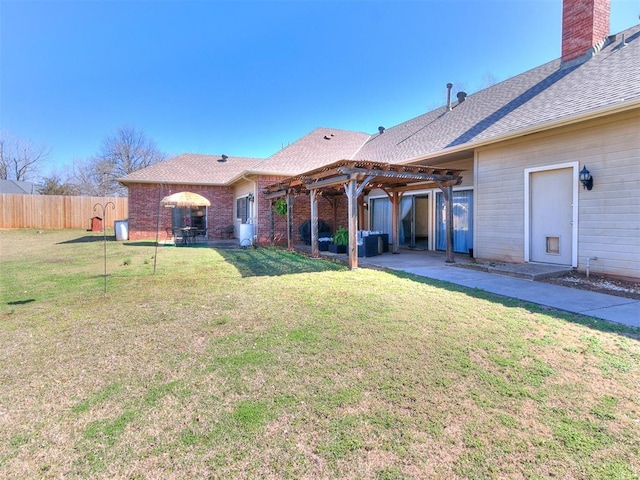 back of property with brick siding, fence, a lawn, a pergola, and a patio