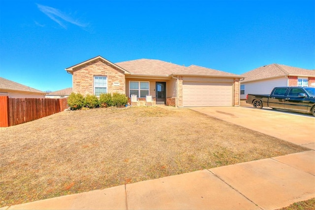 single story home featuring driveway, brick siding, an attached garage, and fence