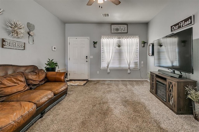 carpeted living area featuring visible vents, baseboards, and ceiling fan