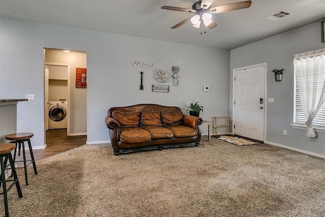 carpeted living area featuring washer / clothes dryer, a ceiling fan, visible vents, and baseboards