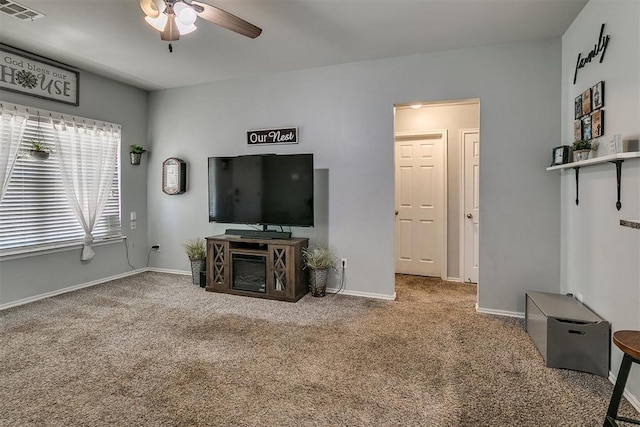 living room featuring a ceiling fan, visible vents, carpet floors, and baseboards