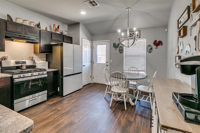 kitchen featuring visible vents, under cabinet range hood, freestanding refrigerator, light countertops, and gas range