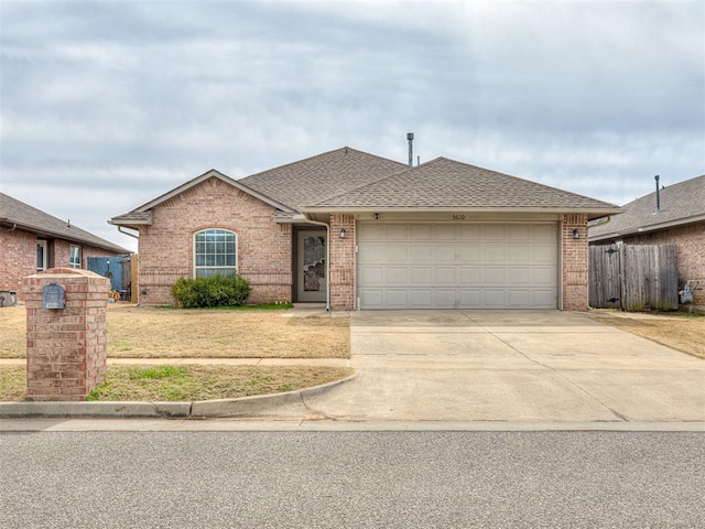 view of front facade featuring brick siding, concrete driveway, a shingled roof, and a garage