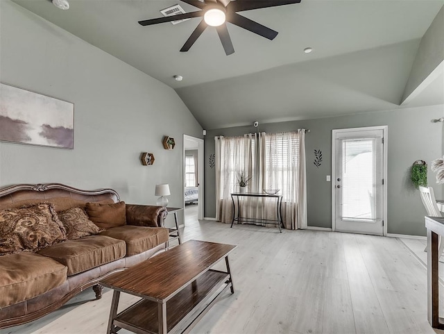 living area featuring visible vents, baseboards, light wood-style floors, lofted ceiling, and ceiling fan