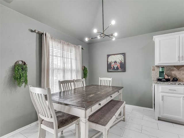 dining area with lofted ceiling, a notable chandelier, baseboards, and marble finish floor