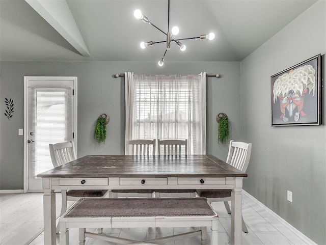 dining room featuring lofted ceiling, a notable chandelier, light wood-style floors, and baseboards