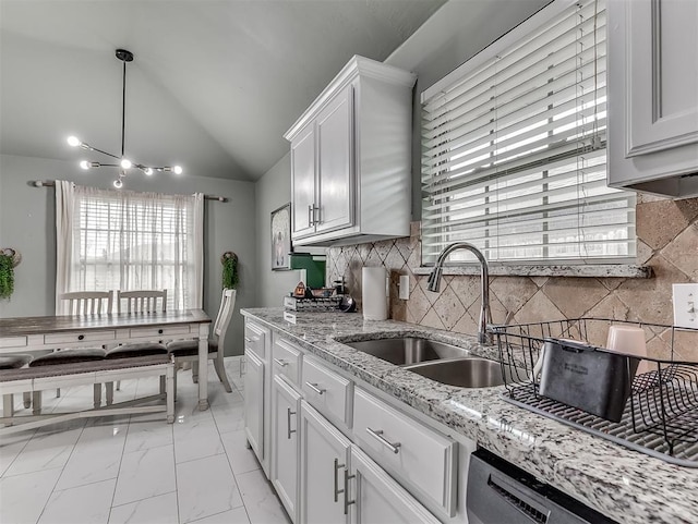 kitchen with dishwasher, lofted ceiling, white cabinets, marble finish floor, and a sink