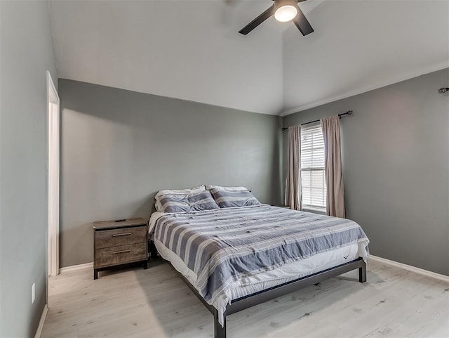 bedroom with baseboards, light wood-style floors, and vaulted ceiling