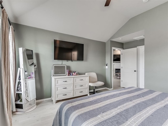 bedroom featuring baseboards, light wood finished floors, ceiling fan, and vaulted ceiling