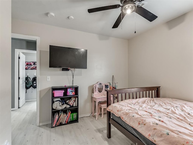 bedroom with baseboards, light wood-style floors, and a ceiling fan