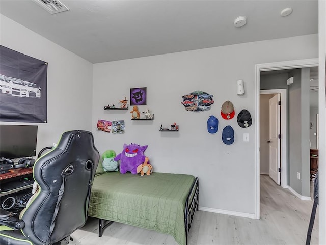 bedroom featuring visible vents, baseboards, and wood finished floors