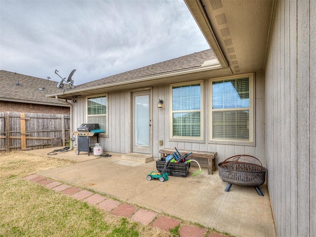 exterior space with a yard, roof with shingles, a patio, and fence