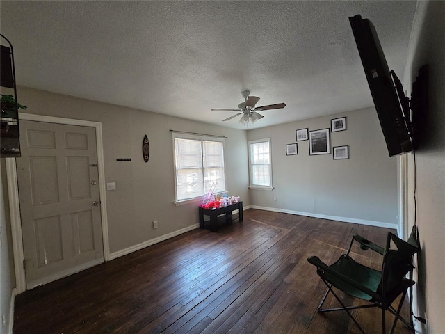 sitting room featuring hardwood / wood-style flooring, a ceiling fan, baseboards, and a textured ceiling