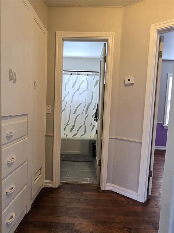 hall featuring baseboards and dark wood-style floors