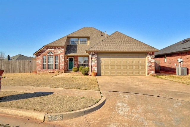 view of front of property featuring fence, brick siding, driveway, and roof with shingles