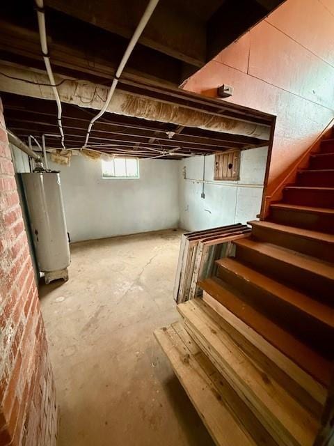 basement featuring water heater and stairs