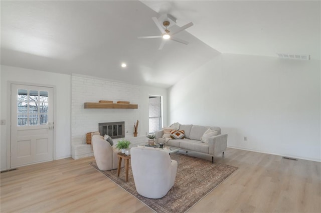 living room with visible vents, wood finished floors, and vaulted ceiling