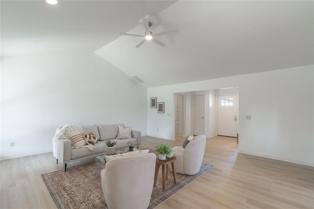 living area featuring vaulted ceiling, a ceiling fan, light wood-type flooring, and visible vents