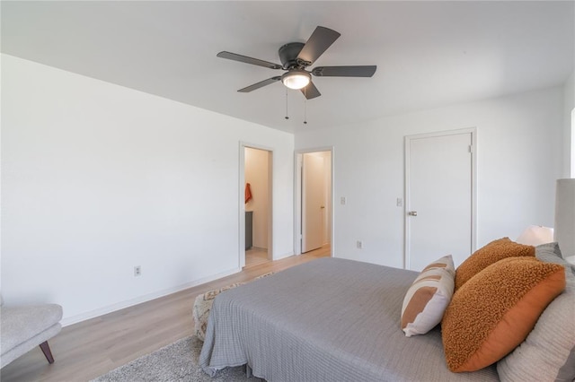 bedroom featuring light wood-style flooring, connected bathroom, baseboards, and ceiling fan