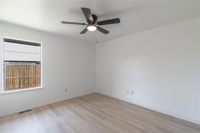 spare room featuring ceiling fan, baseboards, visible vents, and light wood-type flooring