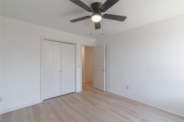 unfurnished bedroom featuring baseboards, light wood-style floors, a closet, and ceiling fan